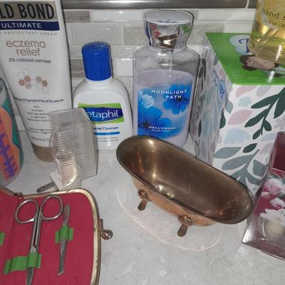 Box of hair curlers, nail care kit, soaps, lotions, Kleenex, perfumes, and brass bathtub soap holder