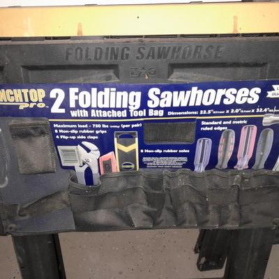 Two new folding sawhorses with attached tool bag, handsaws and a level