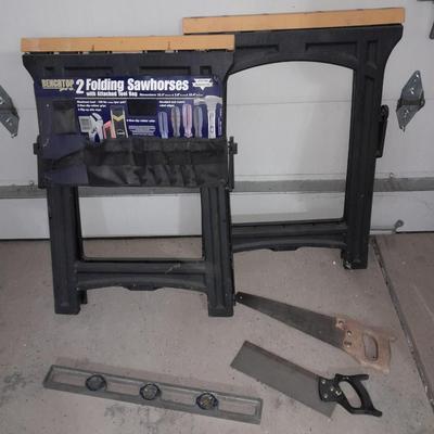 Two new folding sawhorses with attached tool bag, handsaws and a level