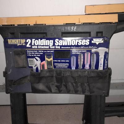Two new folding sawhorses with attached tool bag, handsaws and a level