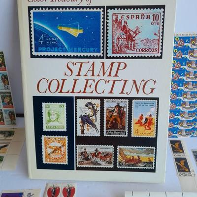 Unused postage stamp collection with Color Treasury of Stamp Collecting book.