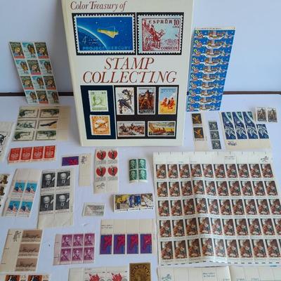 Unused postage stamp collection with Color Treasury of Stamp Collecting book.