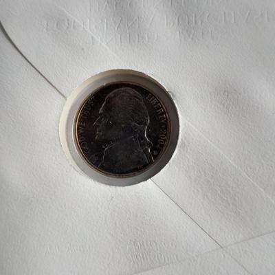Two unopened 2004 United States Louisianna Purchase Five-Cent coins and a Lincoln - Kennedy Penny