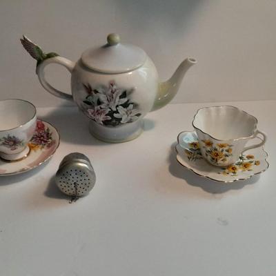 Music box Tea pot teacups with saucers and a tea diffuser