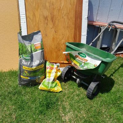 Scotts Deluxe spreader with bag of Scott's turf builder and partial bag of weed & feed