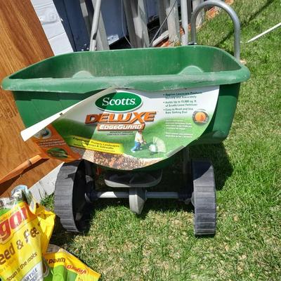 Scotts Deluxe spreader with bag of Scott's turf builder and partial bag of weed & feed