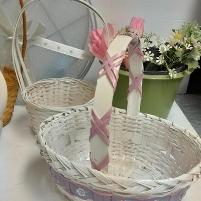 assortment of baskets, pots, bunny statues and faux flowers.