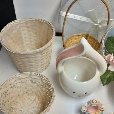 assortment of baskets, pots, bunny statues and faux flowers.