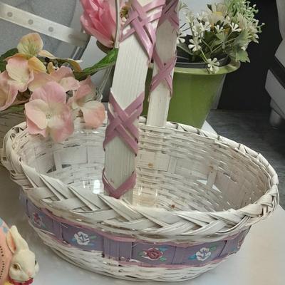 assortment of baskets, pots, bunny statues and faux flowers.