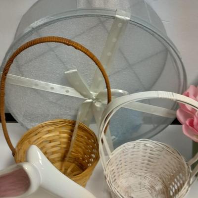assortment of baskets, pots, bunny statues and faux flowers.