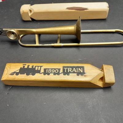 Two wooden train whistles and a vintage metal / tin trombone whistle
