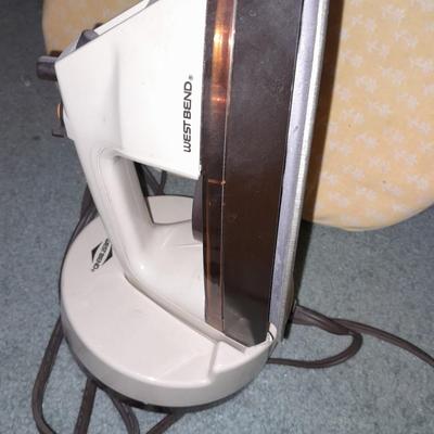 Ironing board with a Westbend power ease cordless Iron and power base charger