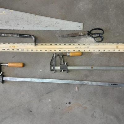 Two clamps, hand saw, claw bar, and a large ruler