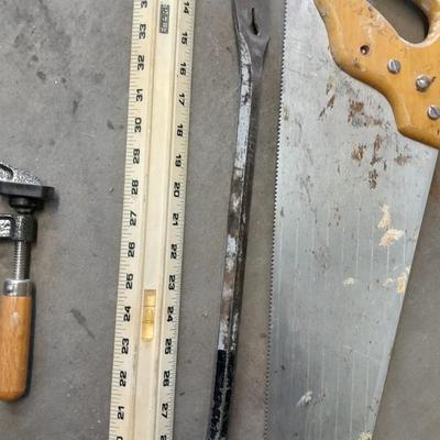 Two clamps, hand saw, claw bar, and a large ruler