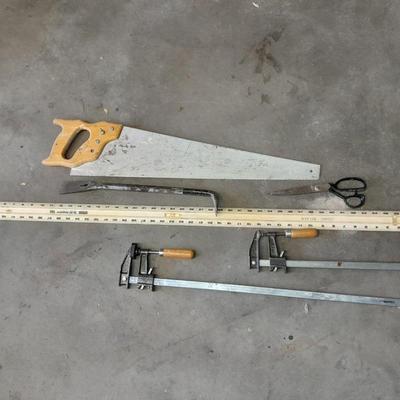 Two clamps, hand saw, claw bar, and a large ruler