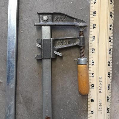 Two clamps, hand saw, claw bar, and a large ruler