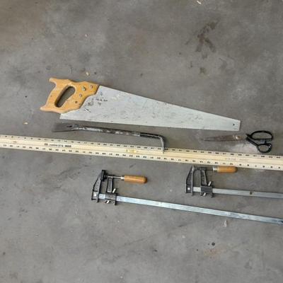 Two clamps, hand saw, claw bar, and a large ruler