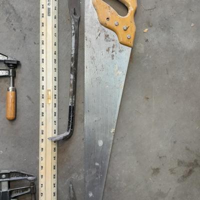 Two clamps, hand saw, claw bar, and a large ruler