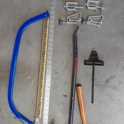 Bow saw, Claw bar, metal yard stick / ruler, and a tack hammer.