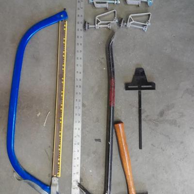 Bow saw, Claw bar, metal yard stick / ruler, and a tack hammer.