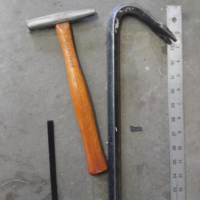 Bow saw, Claw bar, metal yard stick / ruler, and a tack hammer.