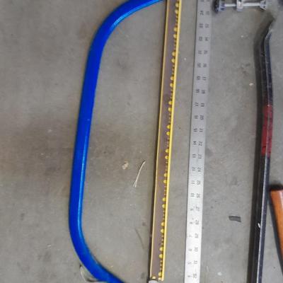 Bow saw, Claw bar, metal yard stick / ruler, and a tack hammer.