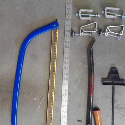 Bow saw, Claw bar, metal yard stick / ruler, and a tack hammer.