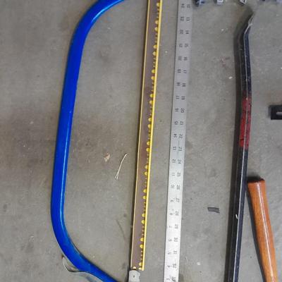 Bow saw, Claw bar, metal yard stick / ruler, and a tack hammer.