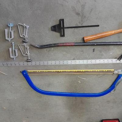 Bow saw, Claw bar, metal yard stick / ruler, and a tack hammer.