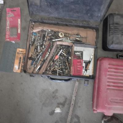 Assortment of drill accessories and empty tool cases