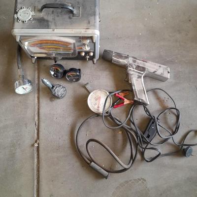 Assortment of gauges, a timing light, and a older battery charger