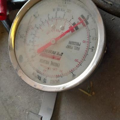 Assortment of gauges, a timing light, and a older battery charger