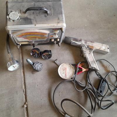 Assortment of gauges, a timing light, and a older battery charger