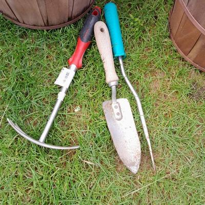 Three flowerpots a small hand shovel, weed puller and rake