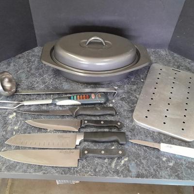 Lidded baking pan with an assortment of knives and electronic thermometer fork