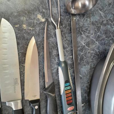 Lidded baking pan with an assortment of knives and electronic thermometer fork