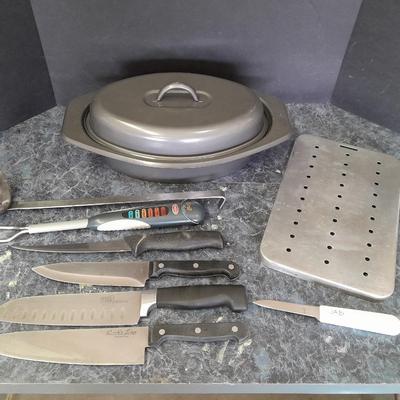 Lidded baking pan with an assortment of knives and electronic thermometer fork