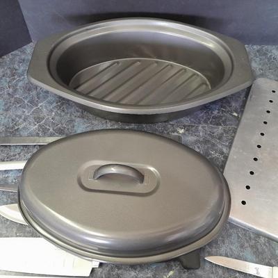 Lidded baking pan with an assortment of knives and electronic thermometer fork
