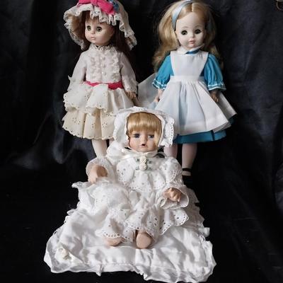 THREE PORCELIAN DOLLS WITH  HAND SEWN OUTFITS