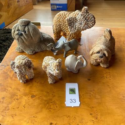 Collection of dog and elephant figurines.