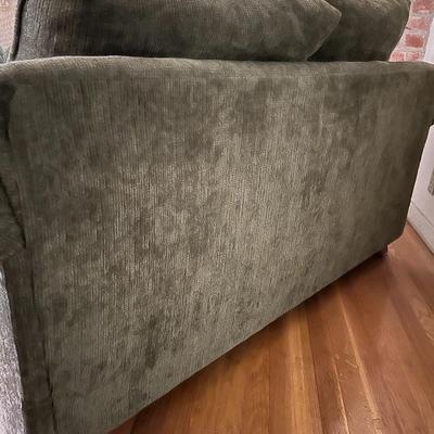 Green upholstered loveseat, with wooden accent