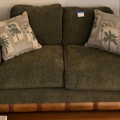 Green upholstered loveseat, with wooden accent