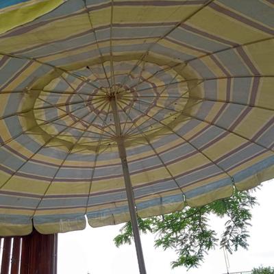 PATIO UMBRELLA WITH CASR IRON HOLDER AND A CAFE STYLE TABLE