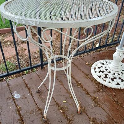 PATIO UMBRELLA WITH CASR IRON HOLDER AND A CAFE STYLE TABLE