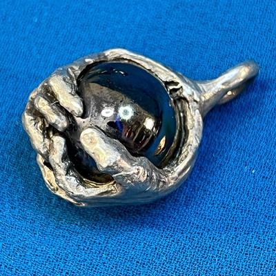 COOL HANDS GRABBING METALLIC BALL PENDANT SCULPTED LOOK