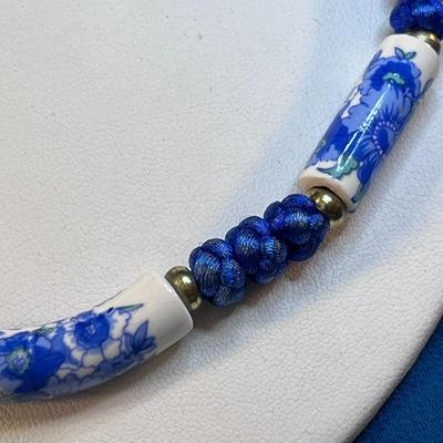 BLUE, WHITE FLORAL BEADS ON BRIGHT BLUE KNOTTED CORD NECKLACE