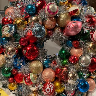 A gorgeous wreath made with vintage ornaments in a large storage box