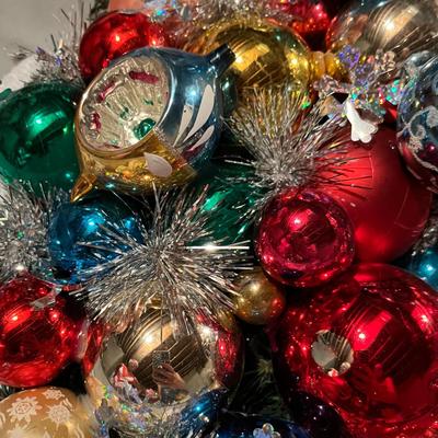 A gorgeous wreath made with vintage ornaments in a large storage box