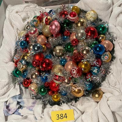 A gorgeous wreath made with vintage ornaments in a large storage box