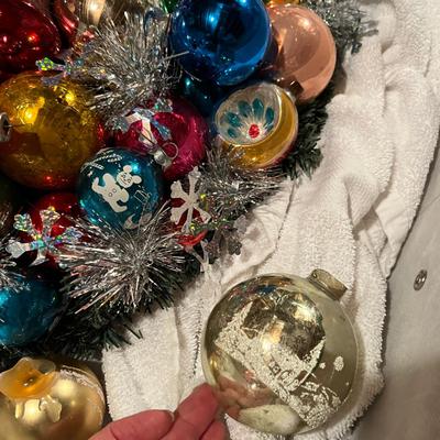 A gorgeous wreath made with vintage ornaments in a large storage box